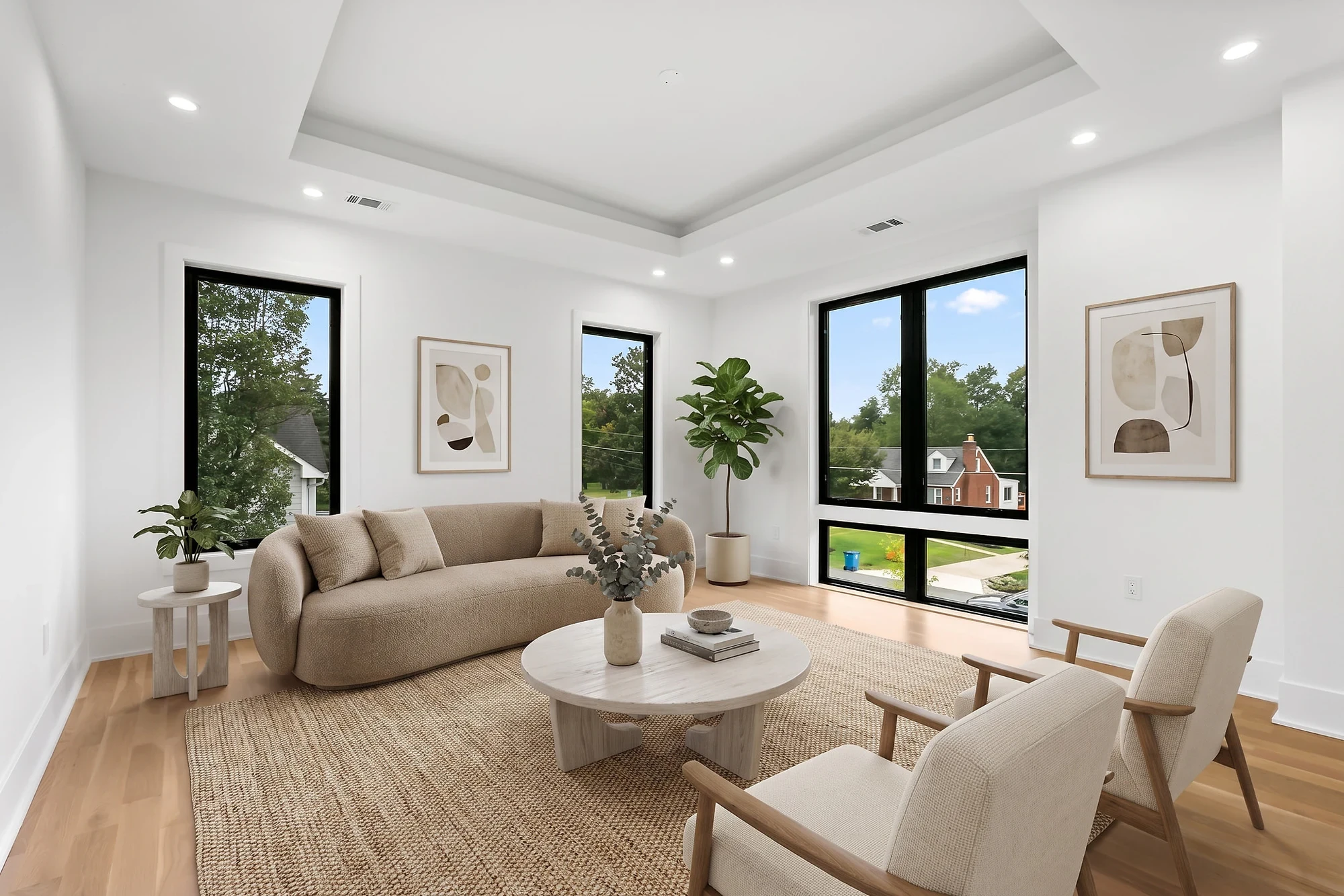 The same living room virtually staged with a curved boucle sofa, round coffee table, cream lounge chairs, and a jute rug — after virtual staging by UMedia