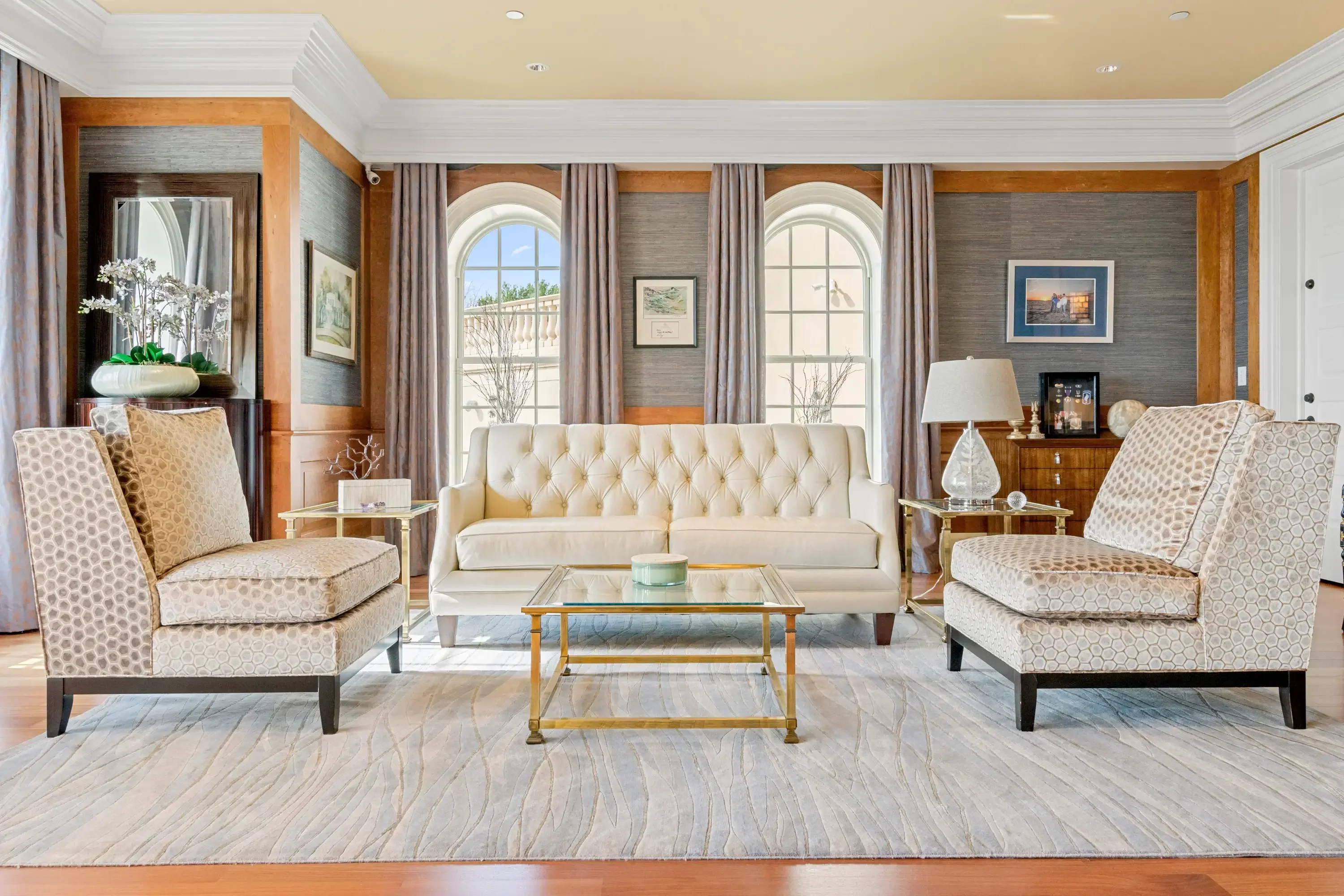 HDR real estate photography of an elegant formal living room with tufted sofa, arched windows, and hardwood floors in Washington DC metro area by Umedia