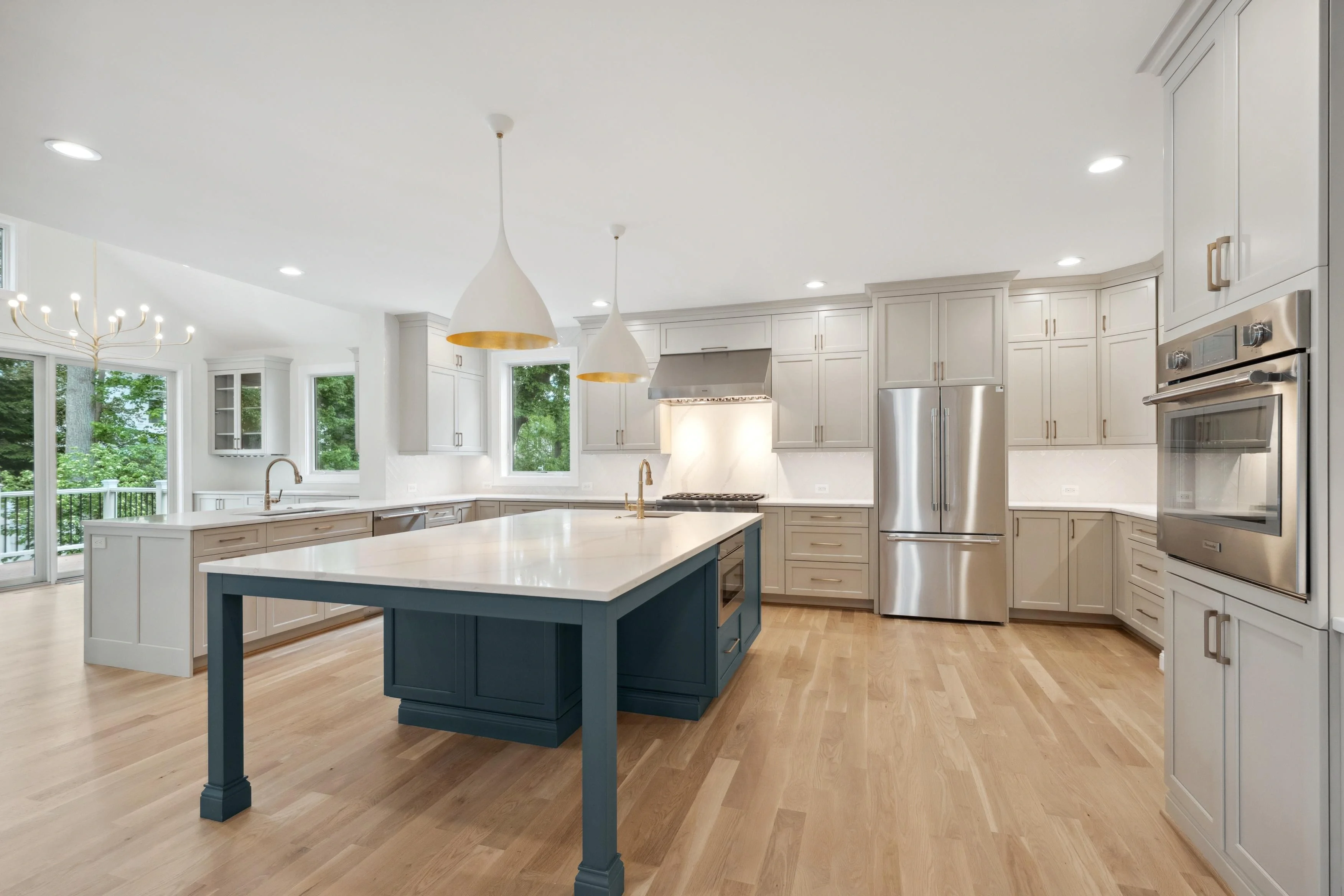 Professional HDR photography of a luxury kitchen with large island, pendant lighting, and stainless steel appliances in Potomac Maryland