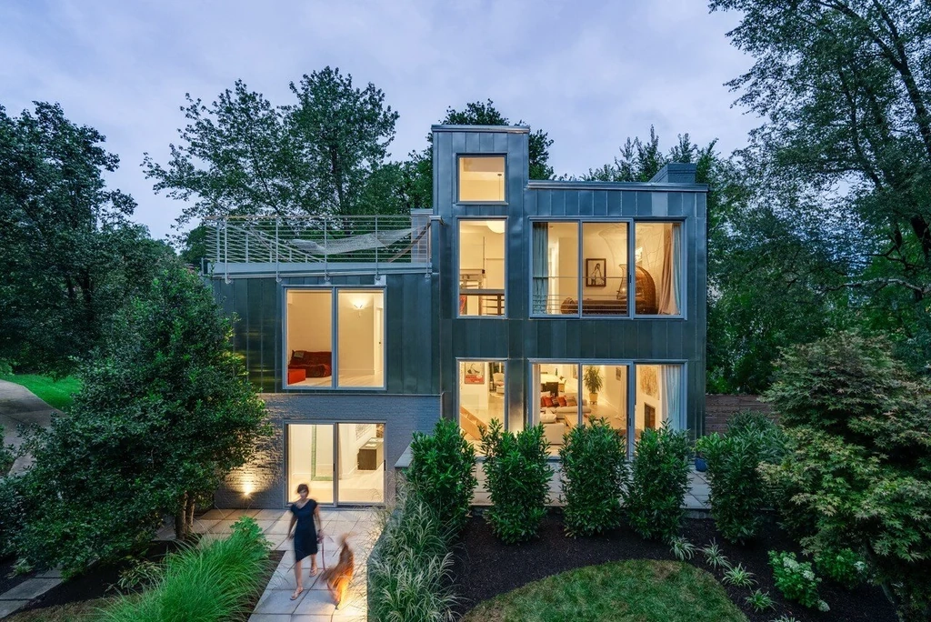 Modern luxury home at twilight with figure on path — editorial architectural photography by Umedia