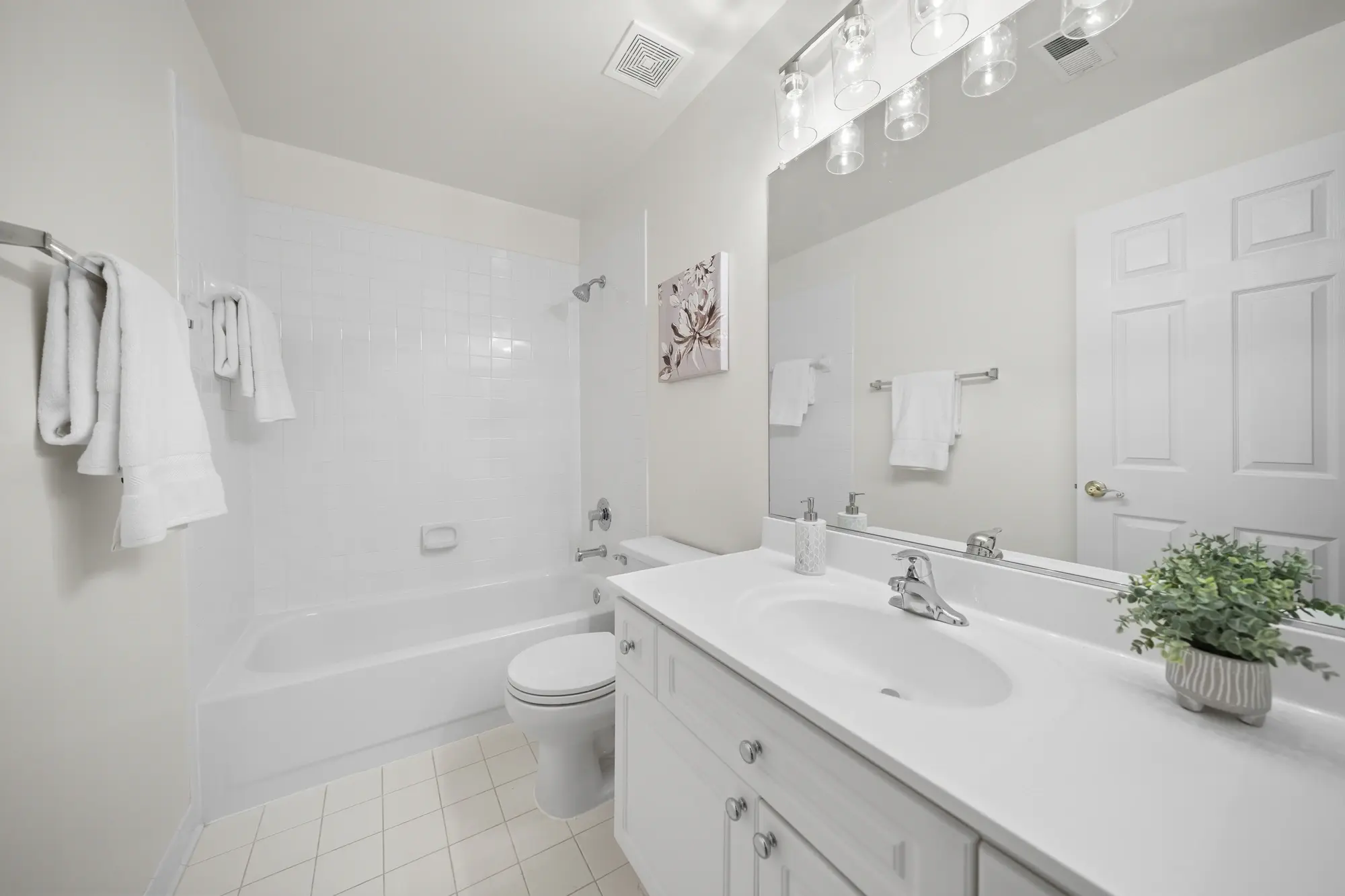 Bright guest bathroom in Oakton VA home with full bathtub, vanity, and modern lighting — photographed by Umedia real estate media