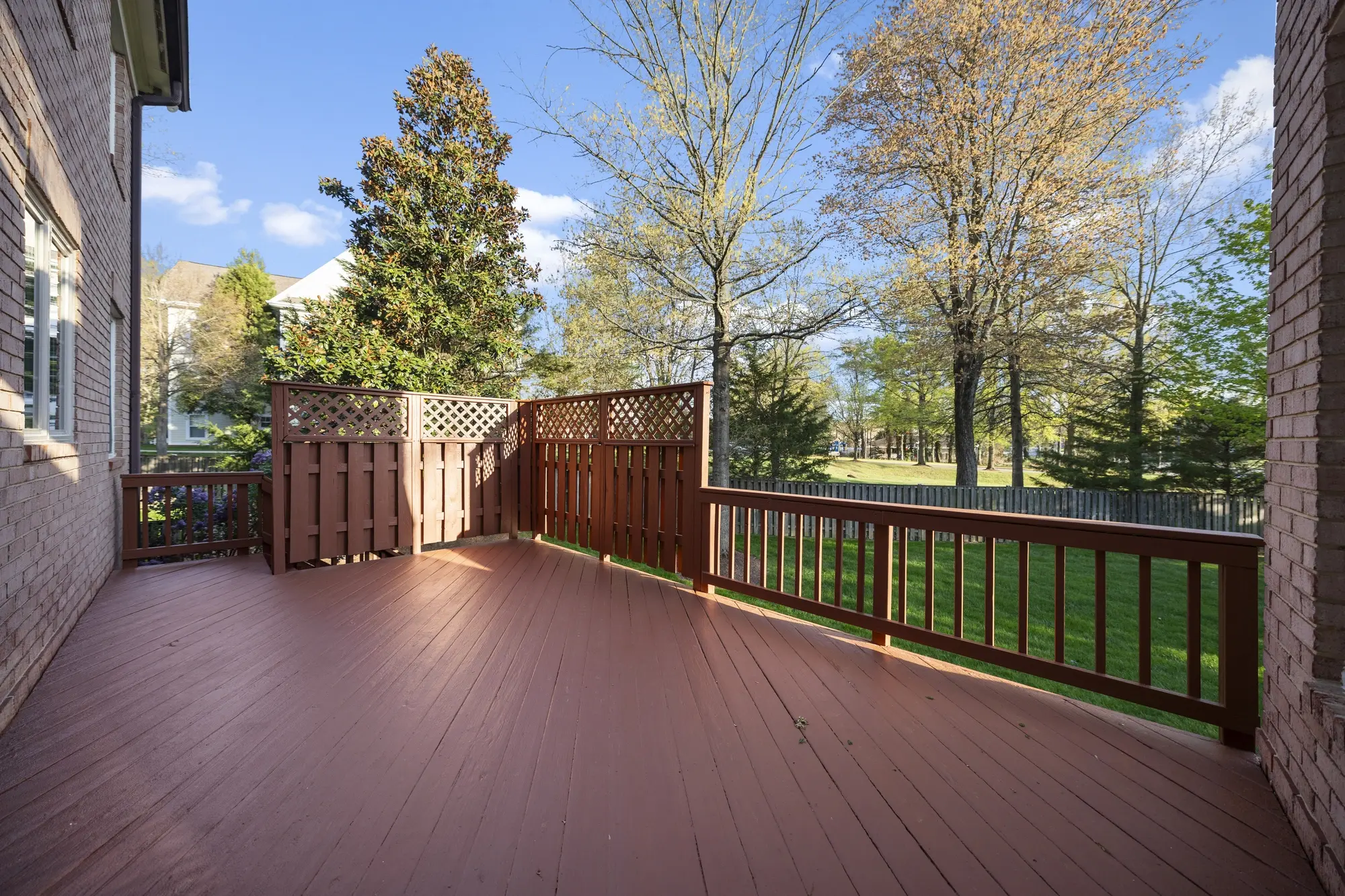 Spacious wooden deck overlooking trees at Oakton VA home captured by Umedia real estate photography