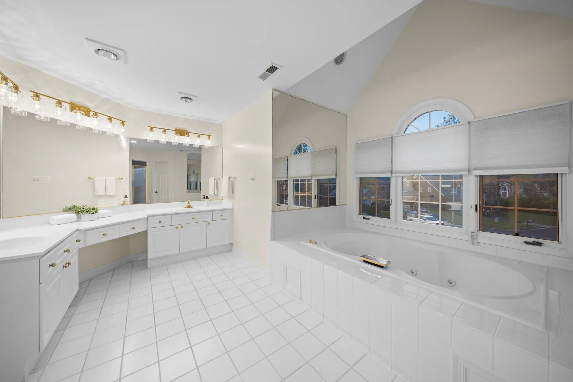 Elegant Oakton VA master bathroom with dual vanity, large mirrors, and soaking tub — professional real estate photography by Umedia