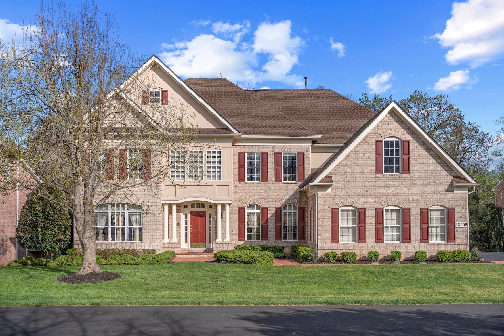 Stunning colonial-style brick home with red shutters, professionally photographed by Umedia for real estate marketing in the DMV area