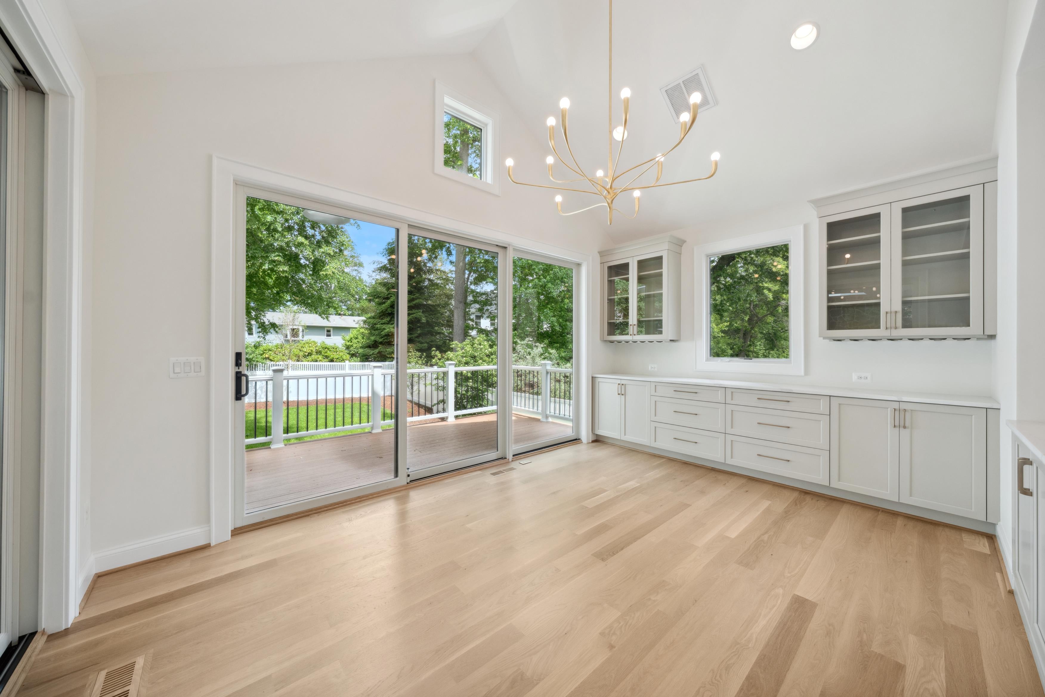 Bright dining space with modern chandelier, built-in cabinetry, and sliding glass doors, photographed by Umedia for real estate media in the DMV