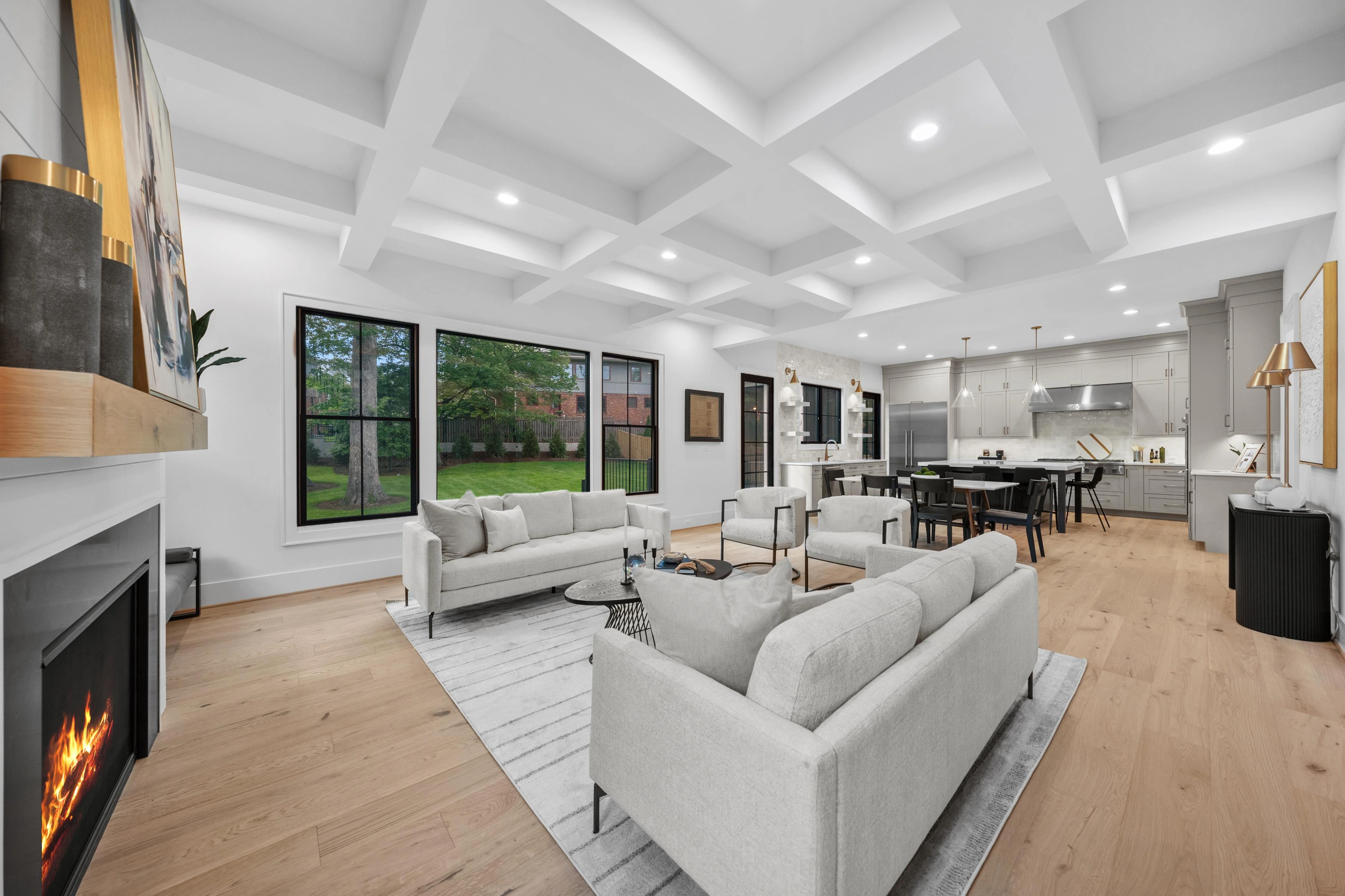 Spacious open-concept living room with coffered ceiling, fireplace, and views to kitchen in Arlington VA home