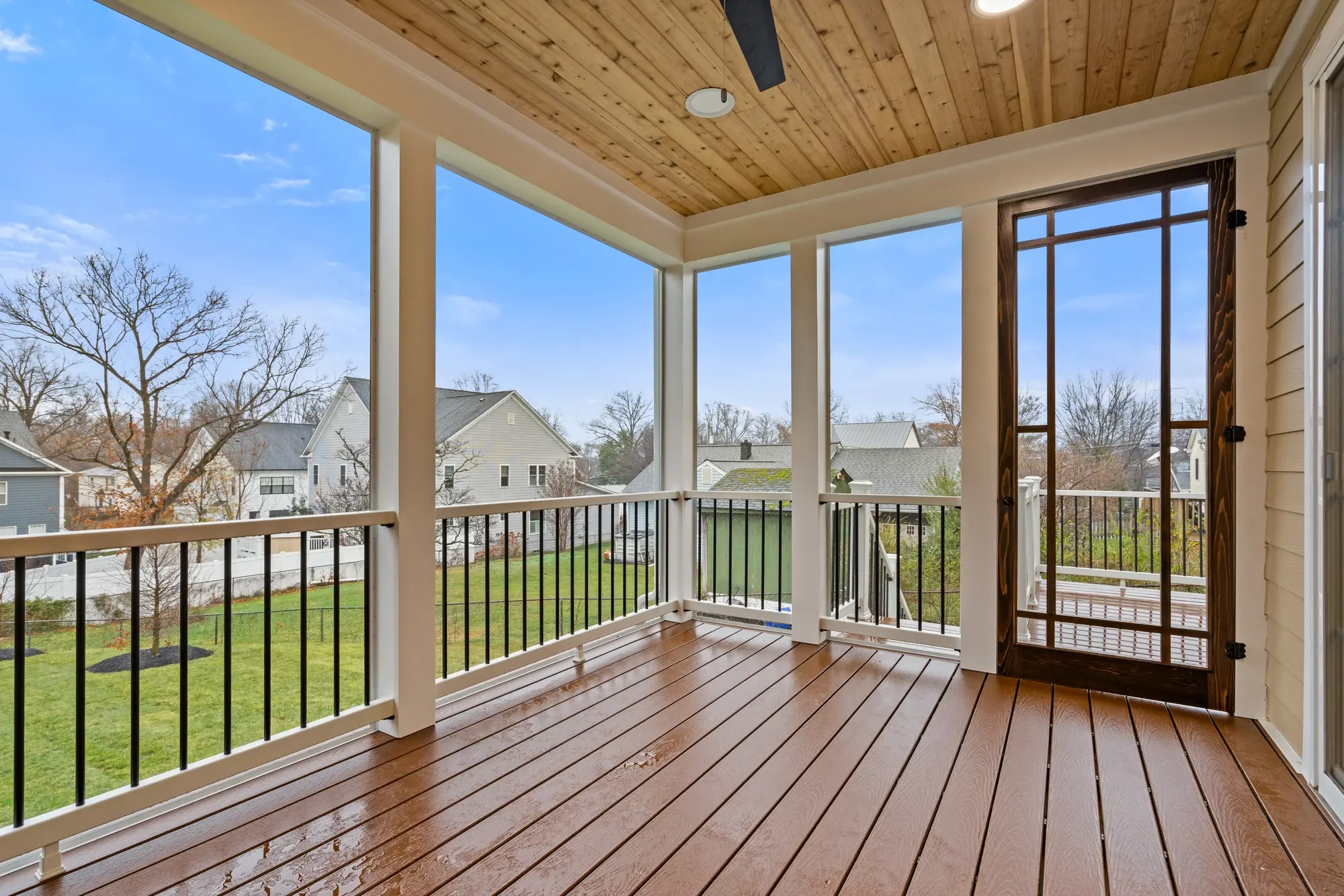 Screened-in porch with ceiling fan, outdoor seating area, and backyard views