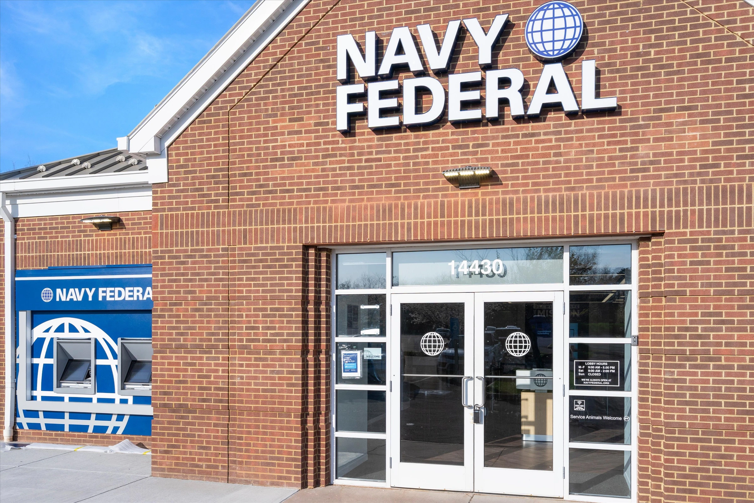 Navy Federal Credit Union entrance close-up with brick gable, globe logo, address 14430, ATM kiosk, and glass double doors