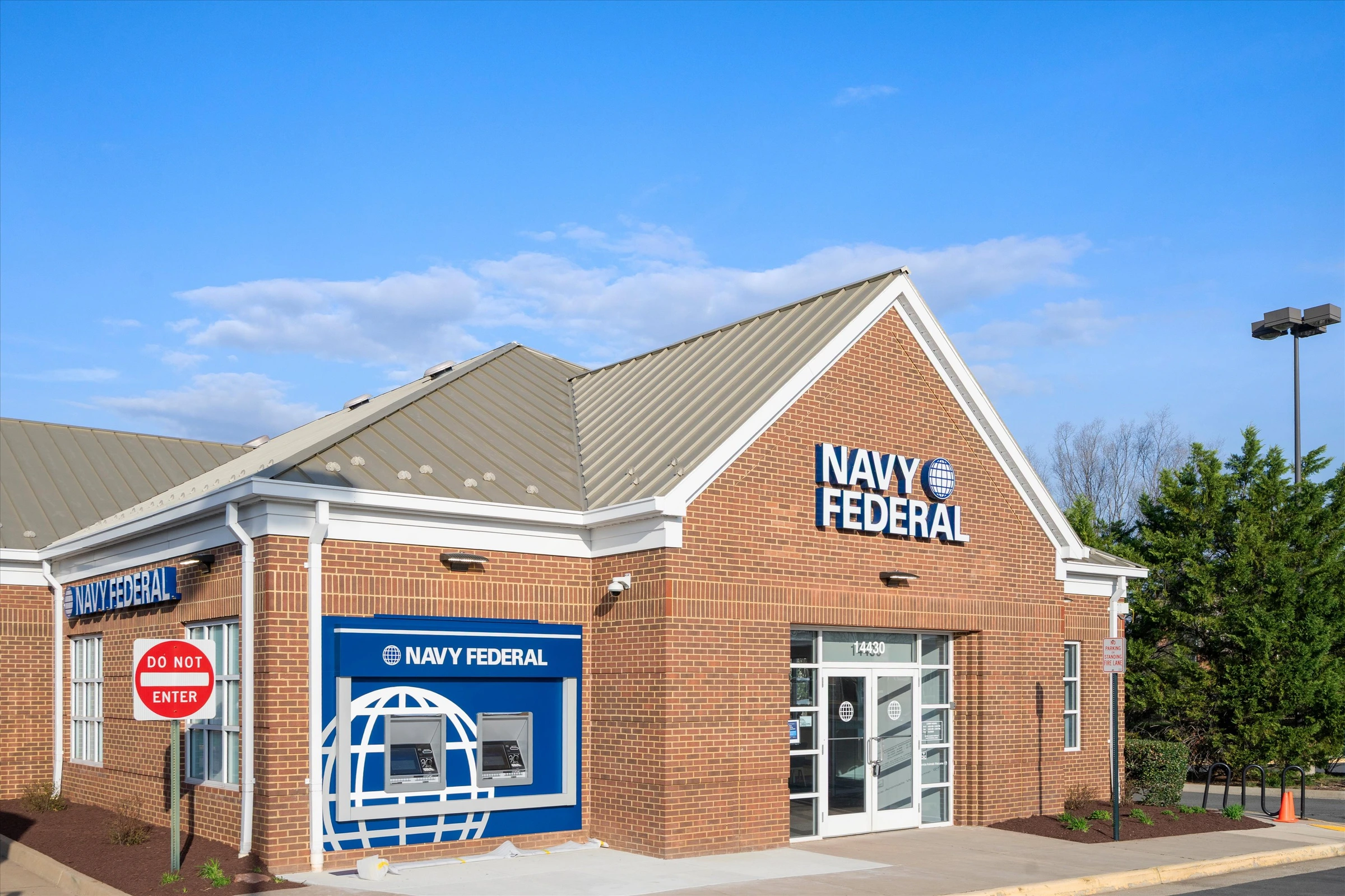 Wide corner view of Navy Federal Credit Union Chantilly VA branch showing full brick building, metal roof, landscaping, and ATM station