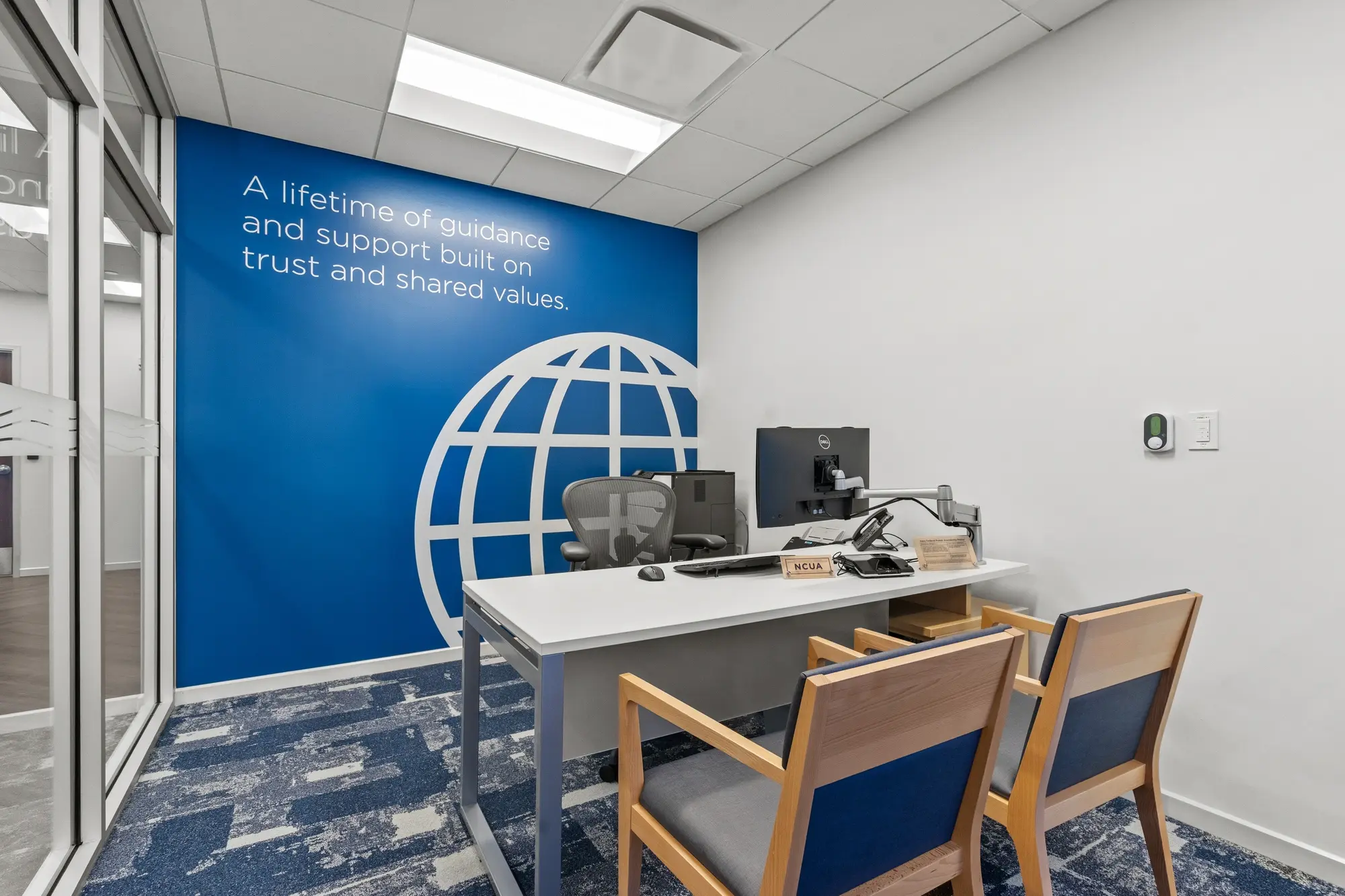 Main lobby with queue stanchions, herringbone flooring, linear LED ceiling lights, and "Our Members Are The Mission" wall graphic