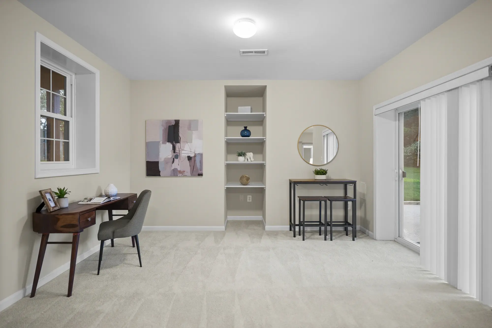 Staged home office with desk, shelving, and sliding glass door