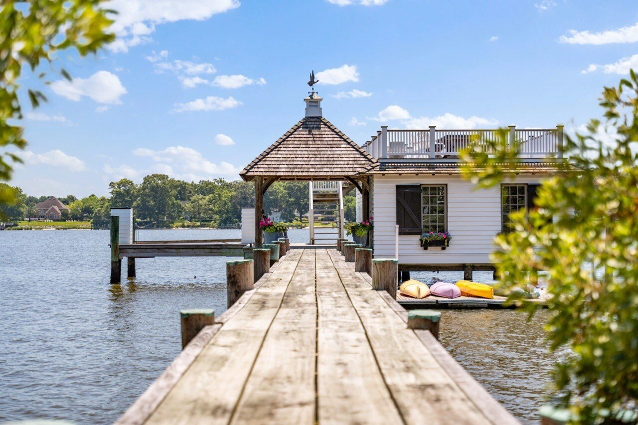 Waterfront dock and boathouse with kayaks on a sunny day